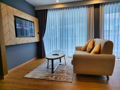 a living room with a couch and a table at 2 BDR Suite in 5 Star Hotel in Rawai Beach