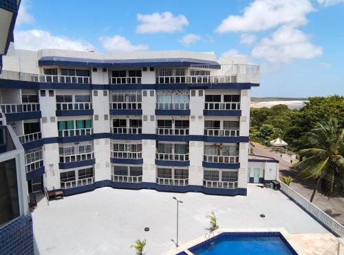 a building with a swimming pool in front of it at Paraiso do Atlantico Para 05 Hospedes in Salinópolis