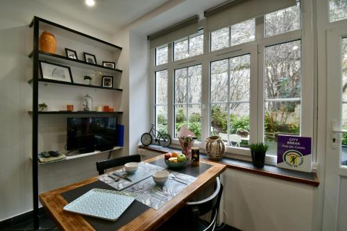 un salon avec une table et des fenêtres dans l'établissement Gite Saint Wulmer Vieille ville, à Boulogne-sur-Mer