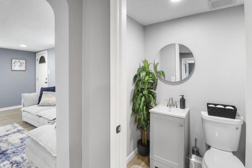a white bathroom with a toilet and a mirror at Beautiful Brookpark House in Brook Park