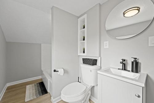 a bathroom with a toilet and a sink and a mirror at Beautiful Brookpark House in Brook Park