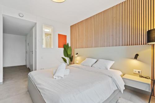 a bedroom with a large bed with white sheets at Comfort & Style in Vibrant Luxembourg Coliving in Luxembourg