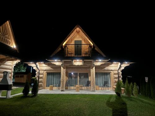 a house with a balcony on top of it at night at Domki 4 Turnie in Ząb