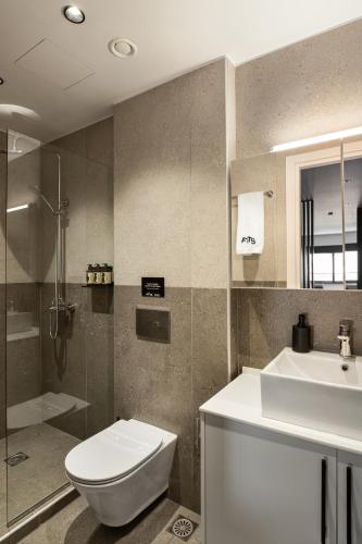 a bathroom with a toilet and a sink and a shower at Fits Living in Athens