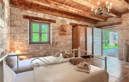 a bedroom with two beds and a stone wall at Villa Roveria in Butkovići