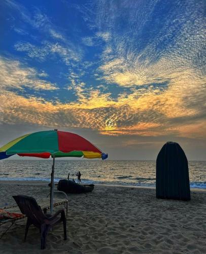 a beach with a chair and an umbrella on the beach at Marari Anandu Beach Villa in Mararikulam