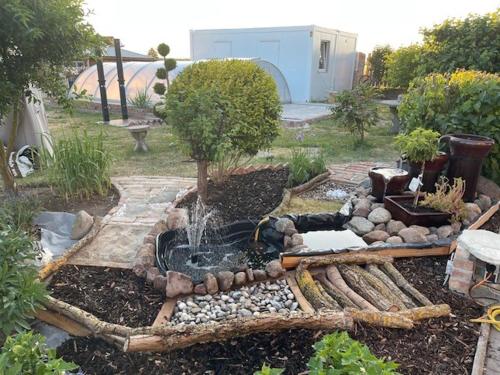 a garden with a fountain in the middle of a yard at Urlaub nahe der Peene nähe der Ostsee in Rustow