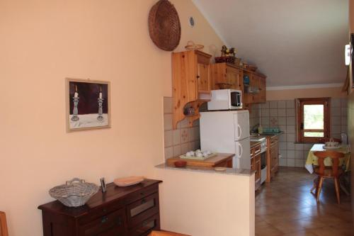 a kitchen with a white refrigerator and wooden cabinets at Uliveto in Gioiosa Marea