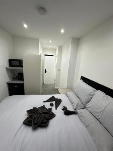 a bedroom with a white bed with black items on it at Near London Soho and Oxford Circus in London