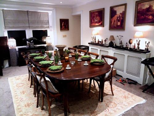 a dining room with a wooden table and chairs at The West Highland Way Hotel Accommodation in Glasgow