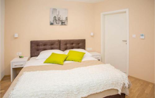 a bedroom with a large bed with two yellow pillows at Villa Orljak in Buzet