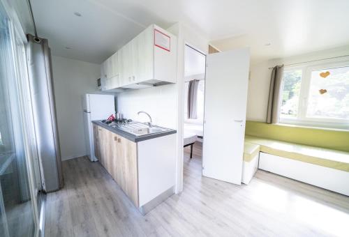 a small kitchen with a sink and a refrigerator at Eirl DOLOMITES Retreat Sappada in Sappada