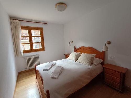 a bedroom with a bed with two towels on it at InmoCyma Pico Posets Benasque in Benasque