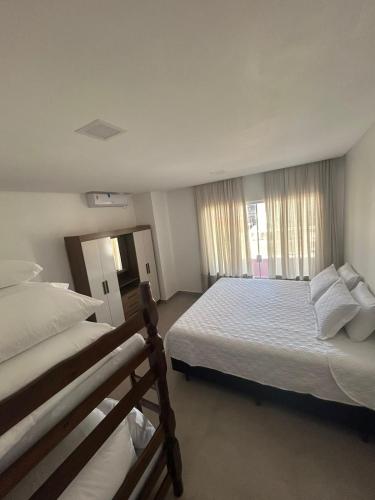 a bedroom with two beds and a large window at Casa Pérolas do Mar in Balneário Camboriú
