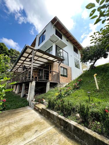 a house on top of a grassy hill at Meraki Cabaña Privada in Pereira