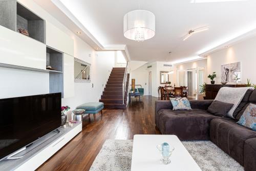 a living room with a couch and a tv at Moradia Vista Atlântico in Funchal
