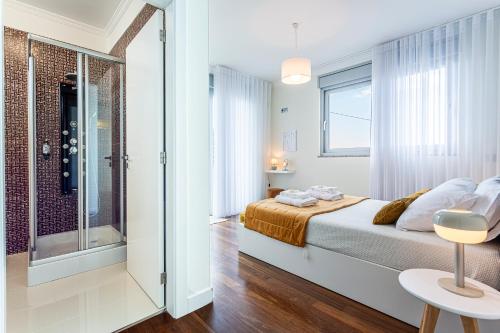 a bedroom with a bed and a walk in shower at Moradia Vista Atlântico in Funchal
