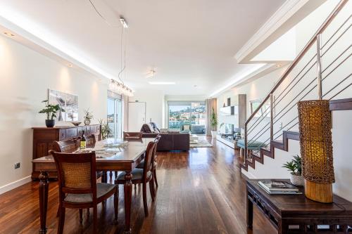 a dining room and living room with a table and chairs at Moradia Vista Atlântico in Funchal