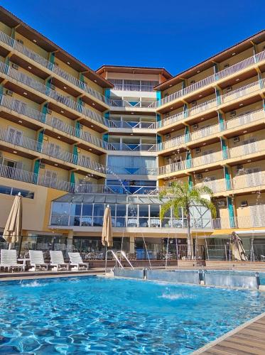 a swimming pool in front of a large building at Hotel Zanon in Águas de Lindoia