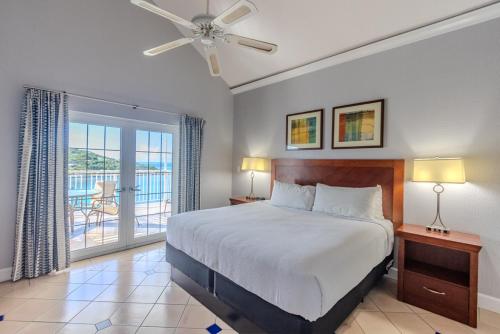 une chambre avec un grand lit et un balcon dans l'établissement Pirate's Pension at Bluebeard's Castle, à Pearson Gardens