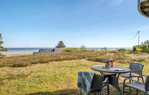 a table and chairs sitting on the grass near the beach at Cozy Home In Glesborg With Kitchen in Glesborg