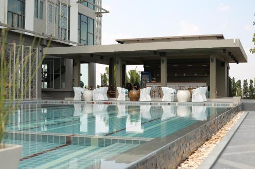 a swimming pool at a hotel with white pillows at Navela Hotel & Convention in Ratchaburi