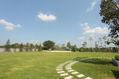 a walkway in a grassy field with a sky at Navela Hotel & Convention in Ratchaburi