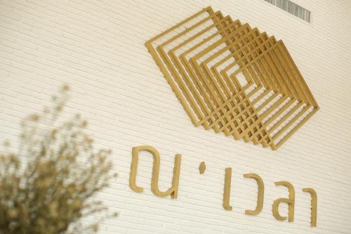 a sign on the side of a building at Navela Hotel & Convention in Ratchaburi
