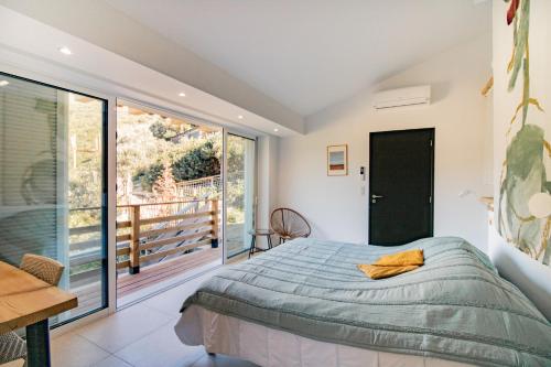 une chambre avec un lit et un balcon dans l'établissement Guetali du Rocher, à Monacia-dʼAullène