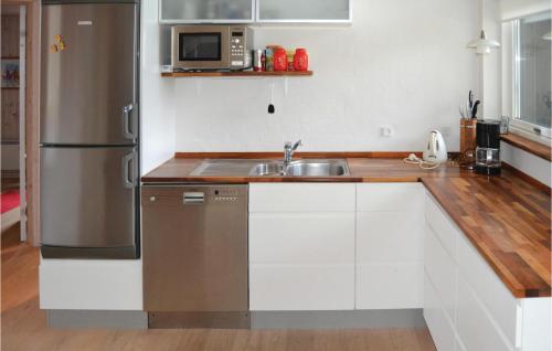 a kitchen with a sink and a stainless steel refrigerator at Holiday Home Kuskevej Jerup in Jerup