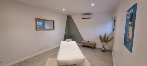 a hospital room with a bed and a mirror at Les terres de Marie - Logements calmes et modernes in La Haye-en-Lyons