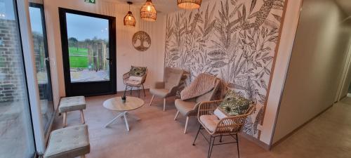 a waiting room with chairs and a wall with a mural at Les terres de Marie - Logements calmes et modernes in La Haye-en-Lyons