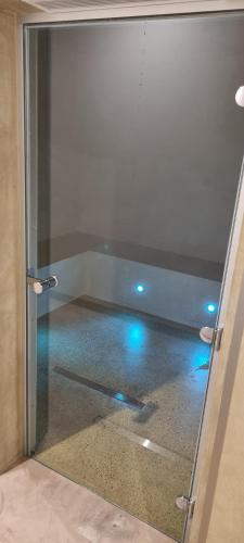 a glass door with blue lights in a room at Les terres de Marie - Logements calmes et modernes in La Haye-en-Lyons