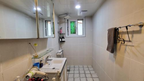 un piccolo bagno con lavandino e specchio di Aewol Gwangryeong House a Jeju