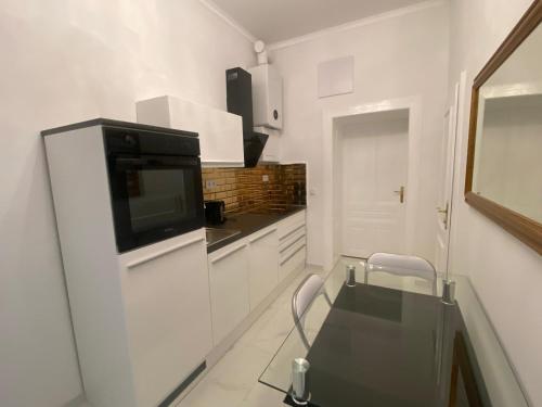 a white kitchen with a glass table and a microwave at Vienna Luxury Dream Home in Vienna