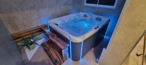 a bath tub in a bathroom with blue lights at Les terres de Marie - Logements calmes et modernes in La Haye-en-Lyons