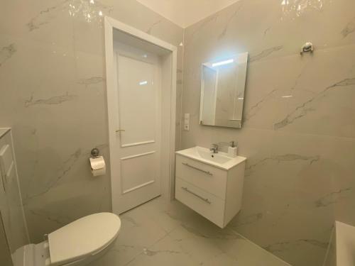 a white bathroom with a toilet and a sink at Vienna Luxury Dream Home in Vienna