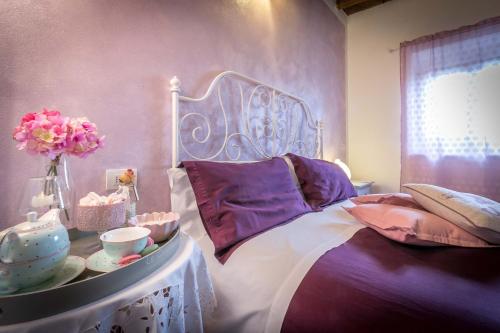 a bedroom with a bed and a table with flowers at Vignolino Country House in Barberino di Mugello