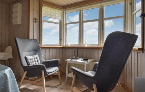two chairs and a table in a room with windows at Holiday Home Lemvig 12 in Lemvig
