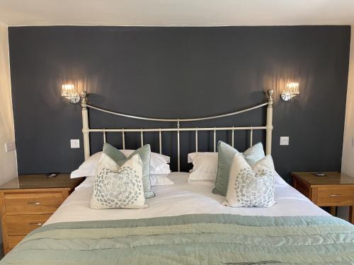 a bedroom with a large bed with white pillows at Bridge Mews in Keswick