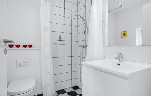 a white bathroom with a sink and a toilet at Three-Bedroom Holiday Home In Grenaa in Grenå