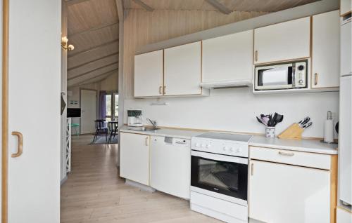 a kitchen with white cabinets and a stove top oven at Amazing Home In Ringkøbing With Sauna in Ringkøbing