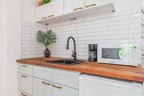 a kitchen counter with a sink and a microwave at Coconut Row Boutique Hotel in Hopkins
