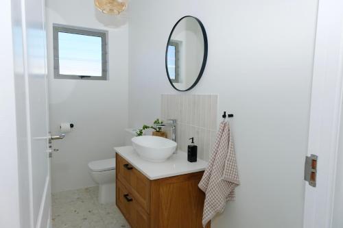 a bathroom with a sink and a mirror on the wall at Sea Lily Holiday Home - Your Coastal Sanctuary! in Stompneusbaai