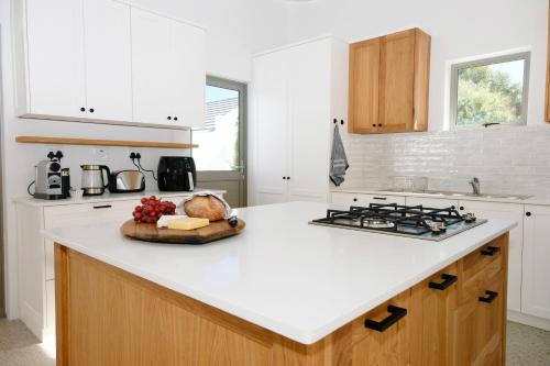 a kitchen with a white counter top and a stove at Sea Lily Holiday Home - Your Coastal Sanctuary! in Stompneusbaai