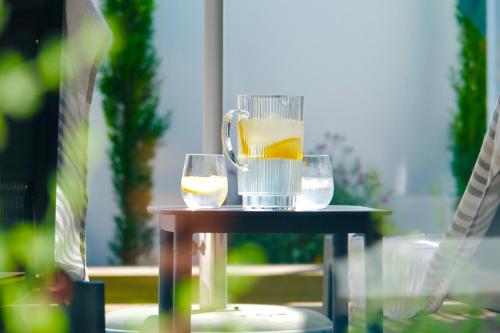 a drink pitcher and two glasses on a table at Sea Lily Holiday Home - Your Coastal Sanctuary! in Stompneusbaai