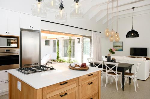 a kitchen with a stove and a dining room at Sea Lily Holiday Home - Your Coastal Sanctuary! in Stompneusbaai