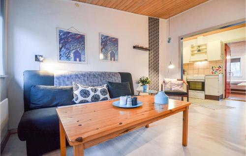 エーベルトフトにあるOne-Bedroom Apartment In Ebeltoftのリビングルーム(青いソファ、木製テーブル付)