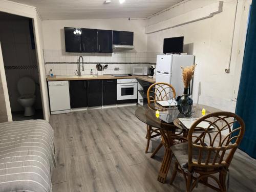 a kitchen with a table and chairs in a room at Loft avec jacuzzi prive in Richerenches