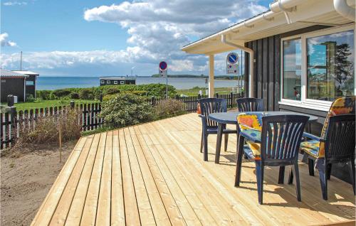 a wooden deck with a table and chairs on a house at Holiday Home Rønde 36 in Rønde